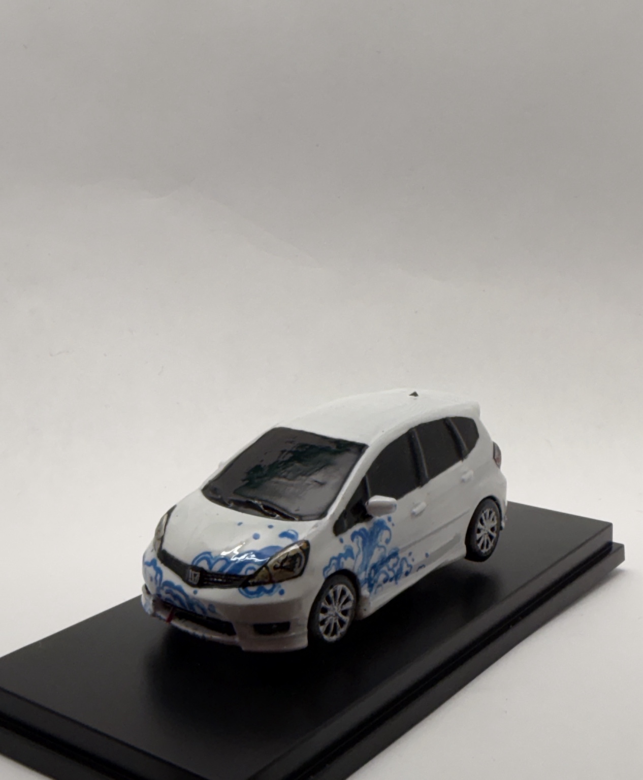 Hand-painted Honda Fit miniature with blue wave artwork, front three-quarter view