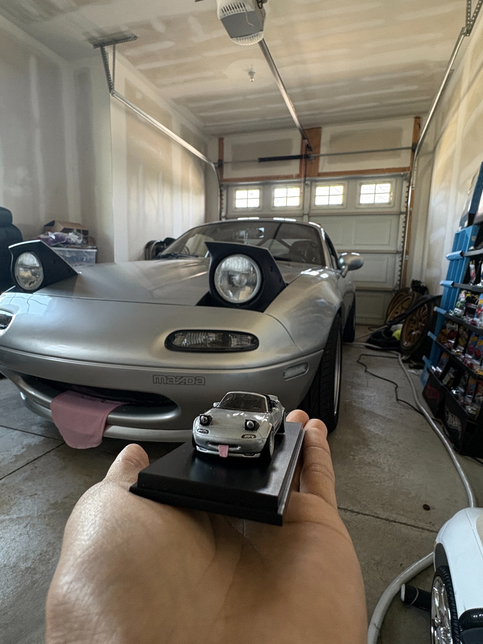 Massive Miata miniature posed with the matching full-size silver Miata